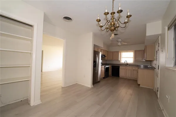 a view of a kitchen with a sink and dishwasher a refrigerator with wooden floor