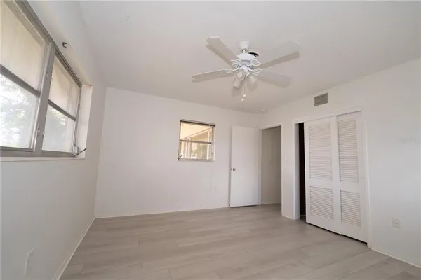 an empty room with a ceiling fan and a window