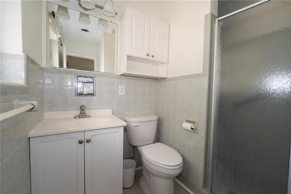 a bathroom with a toilet sink vanity and mirror