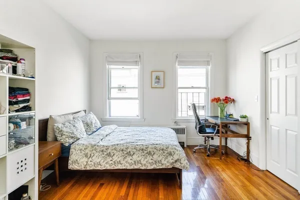 a bedroom with a bed and wooden floor