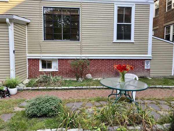 a view of a brick house with a yard and plants