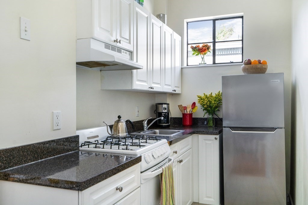 15 Ellery Street, Unit 11 Cambridge, MA 02138 - Photo 7 of 22 a kitchen with stainless steel appliances granite countertop a stove a refrigerator and a sink