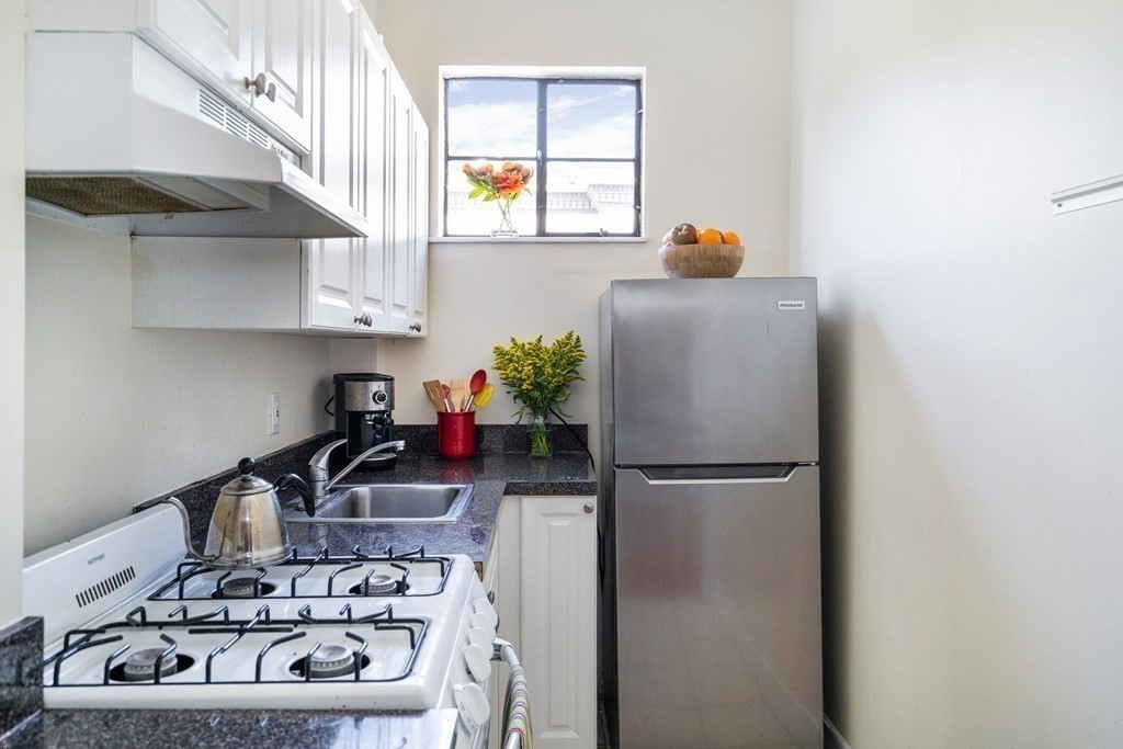15 Ellery Street, Unit 11 Cambridge, MA 02138 - Photo 8 of 22 a kitchen with a refrigerator and a stove
