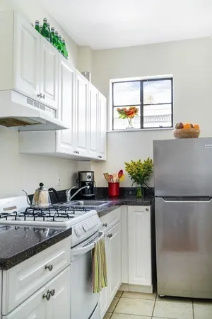 a kitchen with stainless steel appliances granite countertop a sink a stove and a refrigerator