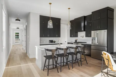 a view of kitchen with refrigerator stove dining table and chairs