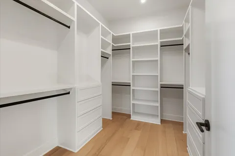 a view of walk in closet with empty racks