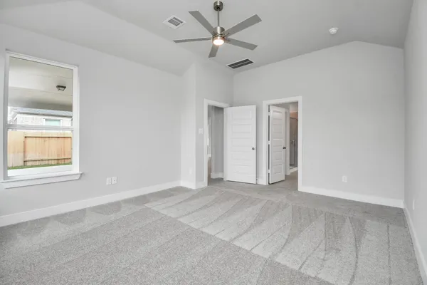 an empty room with windows and fan