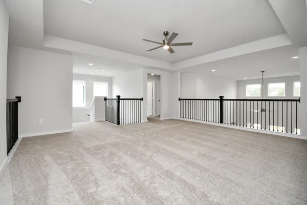 an empty room with windows and ceiling fan