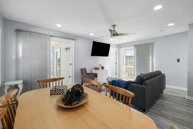 a kitchen with stainless steel appliances granite countertop a stove top oven a sink a dining table and chairs