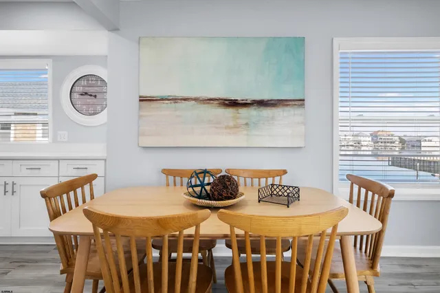 a kitchen with stainless steel appliances granite countertop a refrigerator a stove top oven a sink dishwasher and white cabinets with wooden floor