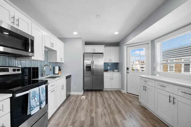 a kitchen with stainless steel appliances kitchen island granite countertop a stove a sink and a microwave