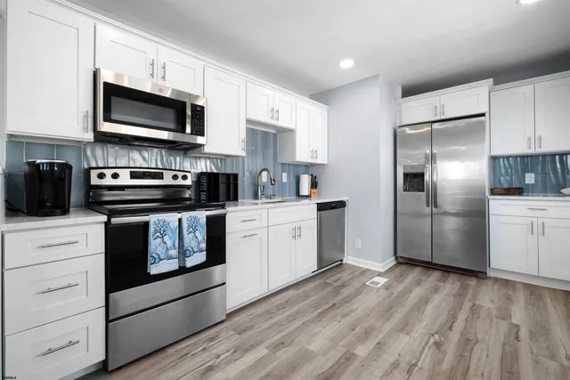 a kitchen with stainless steel appliances granite countertop a stove a microwave and a refrigerator