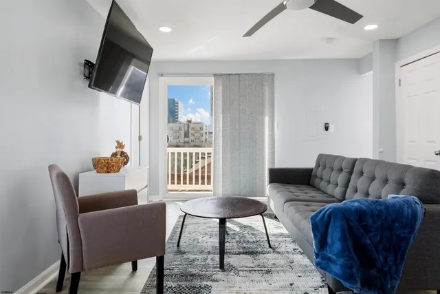 a living room with furniture a dining table and kitchen view