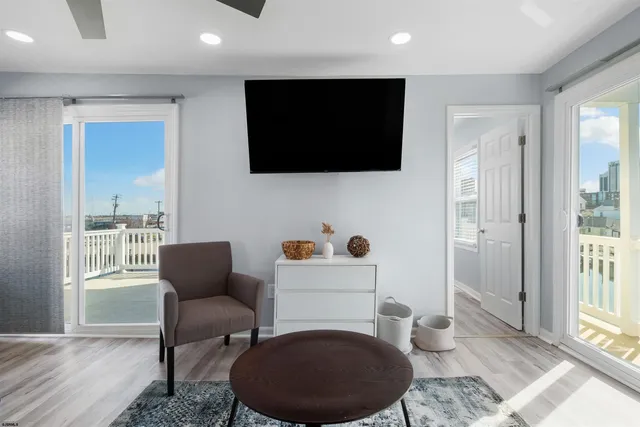 a living room with furniture a flat screen tv and kitchen view