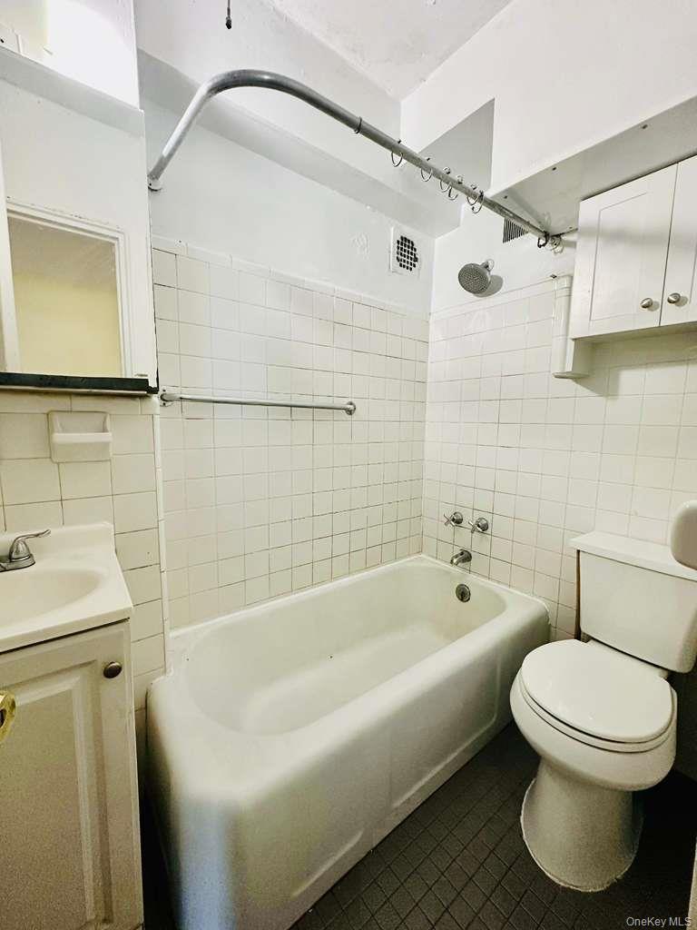 99-60 63rd Road, Unit 7Q Queens, NY 11374 - Photo 11 of 12 a bathroom with a sink and bathtub with toilet