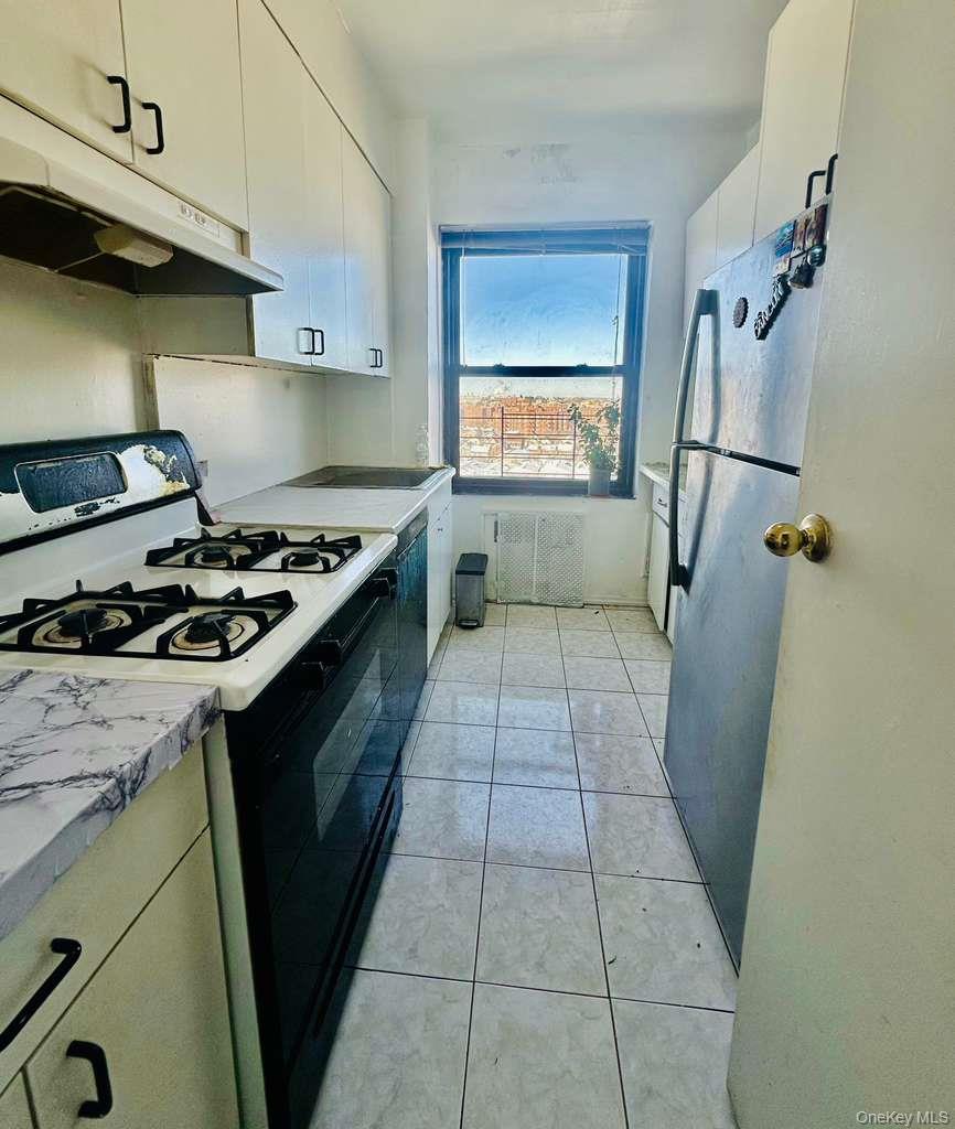99-60 63rd Road, Unit 7Q Queens, NY 11374 - Photo 8 of 12 a kitchen with a sink a stove top oven and cabinets