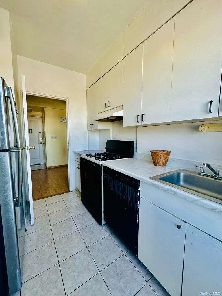 99-60 63rd Road, Unit 7Q Queens, NY 11374 - Photo 9 of 12 a kitchen with stainless steel appliances granite countertop a sink and a refrigerator