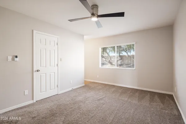an empty room with windows and fan