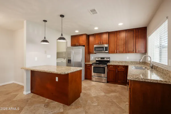 a kitchen with stainless steel appliances granite countertop a sink stove and refrigerator