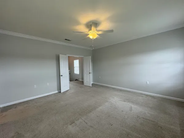 a view of an empty room with a chandelier fan