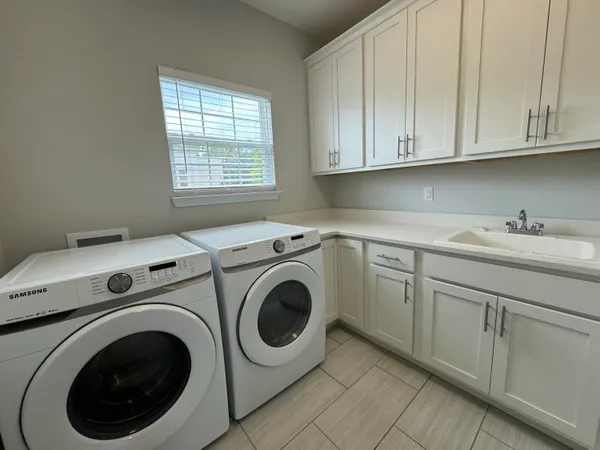 a utility room with sink dryer and washer