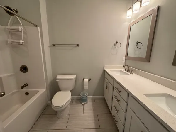 a bathroom with a double vanity sink toilet and shower