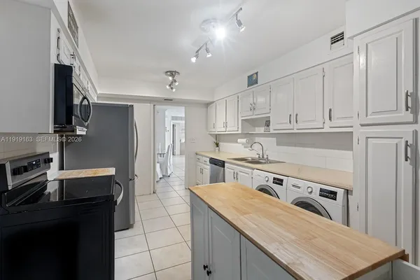 a kitchen with granite countertop a stove sink and refrigerator