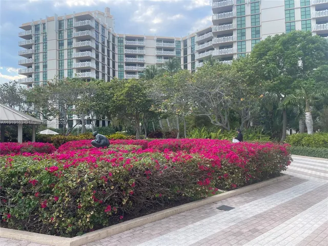 a view of a street with a yard and palm trees