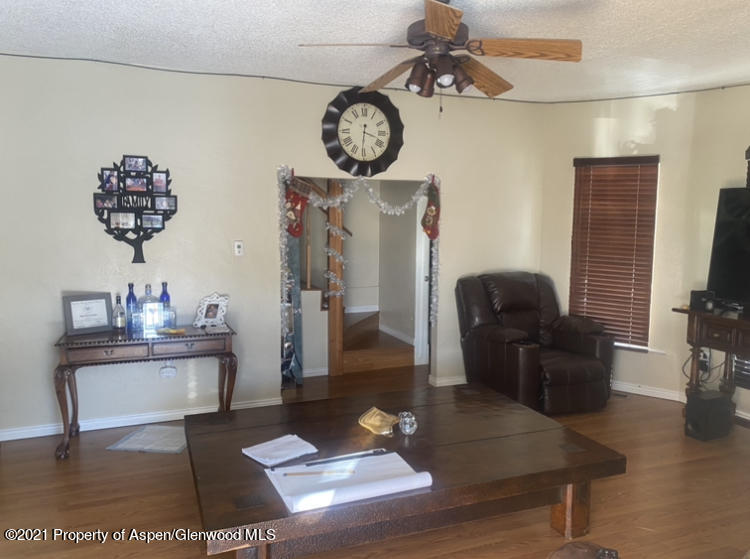 706 Railroad Avenue Rifle, CO 81650 - Photo 4 of 11 a living room with furniture a rug and a flat screen tv
