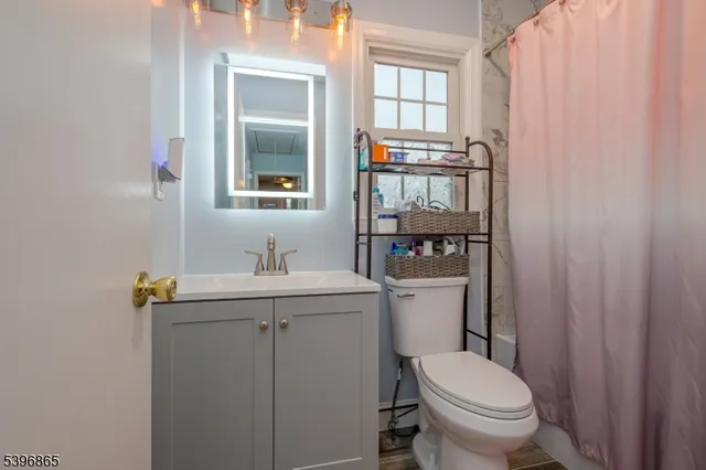 a bathroom with a toilet sink and mirror