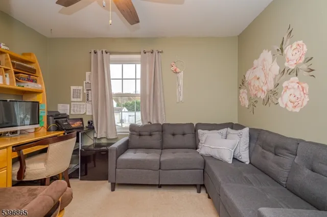 a living room with furniture a flat screen tv and a window