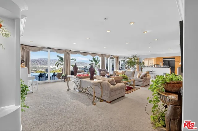 a living room with furniture and a floor to ceiling window