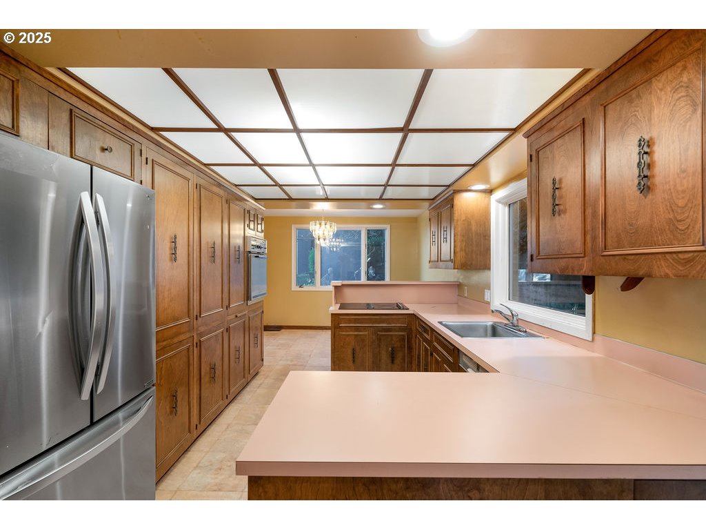 2604 Southwest Buckingham Avenue Portland, OR 97201 - Photo 21 of 32 a kitchen with stainless steel appliances granite countertop a refrigerator and a sink