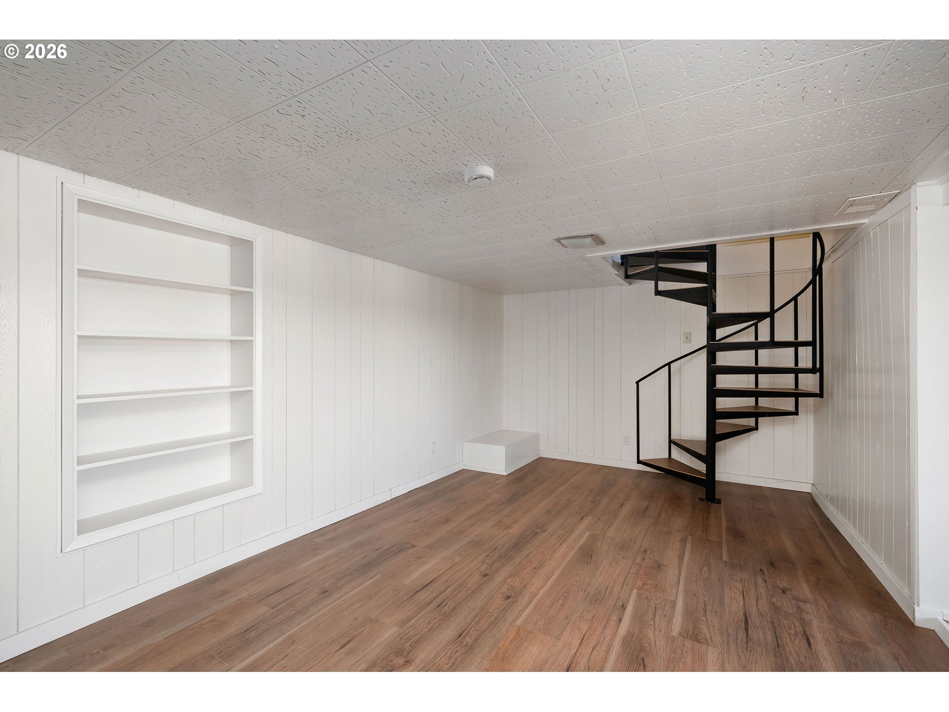 2604 Southwest Buckingham Avenue Portland, OR 97201 - Photo 26 of 32 a view of an empty room with a window and wooden floor