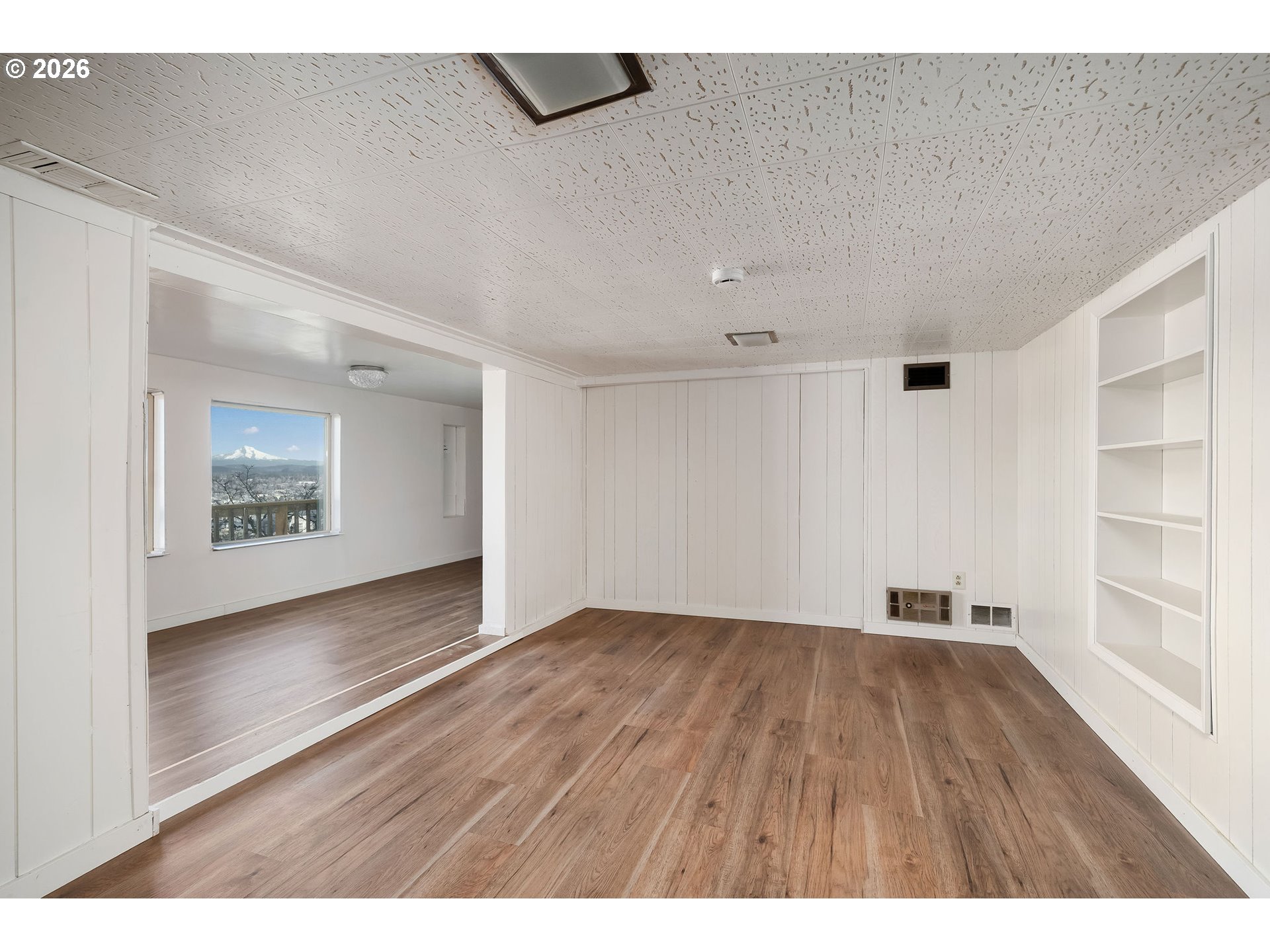2604 Southwest Buckingham Avenue Portland, OR 97201 - Photo 27 of 32 a view of an empty room with a window and wooden floor