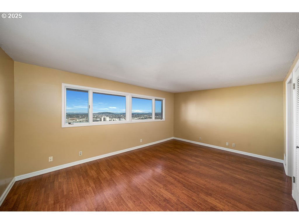 2604 Southwest Buckingham Avenue Portland, OR 97201 - Photo 7 of 32 an empty room with wooden floor and windows