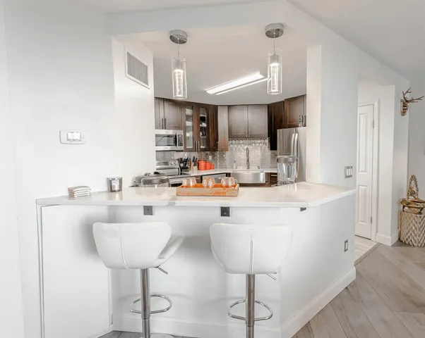 a kitchen with stainless steel appliances a sink and a refrigerator