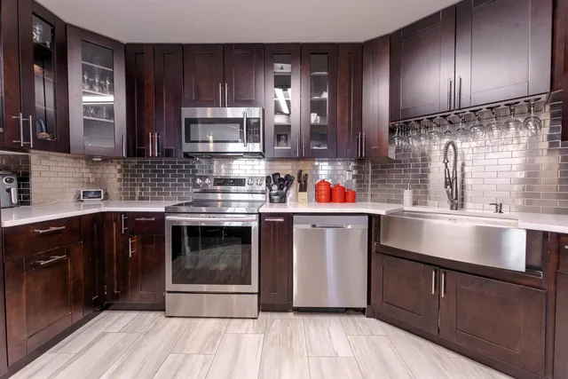 a kitchen with stainless steel appliances granite countertop a stove a sink and a microwave