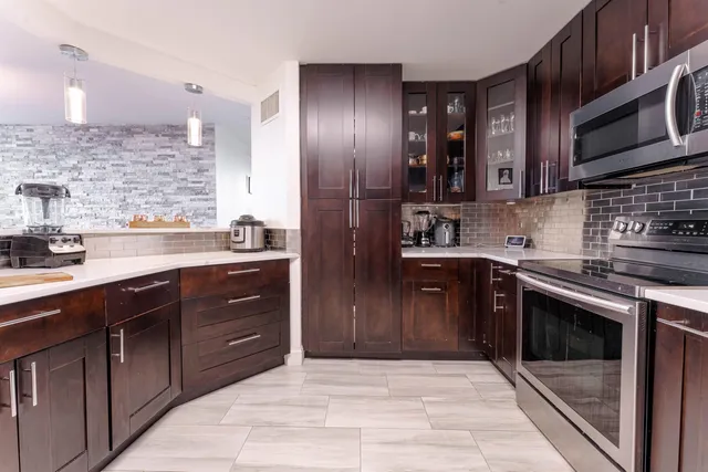 a kitchen with stainless steel appliances granite countertop a stove a sink and a microwave