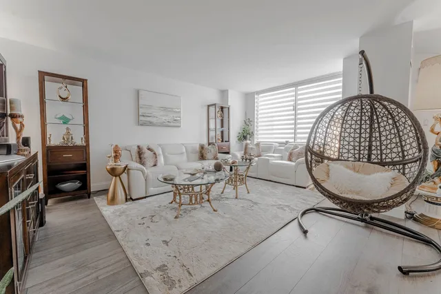 a living room with furniture a table and wooden floor