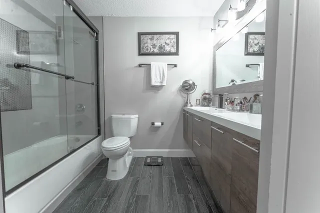 a bathroom with a sink a toilet and shower