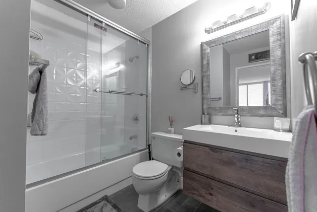a bathroom with a sink toilet a mirror and shower