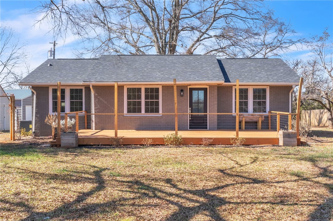 This charming home offers a welcoming facade with an inviting front porch and a classic brick exterior.