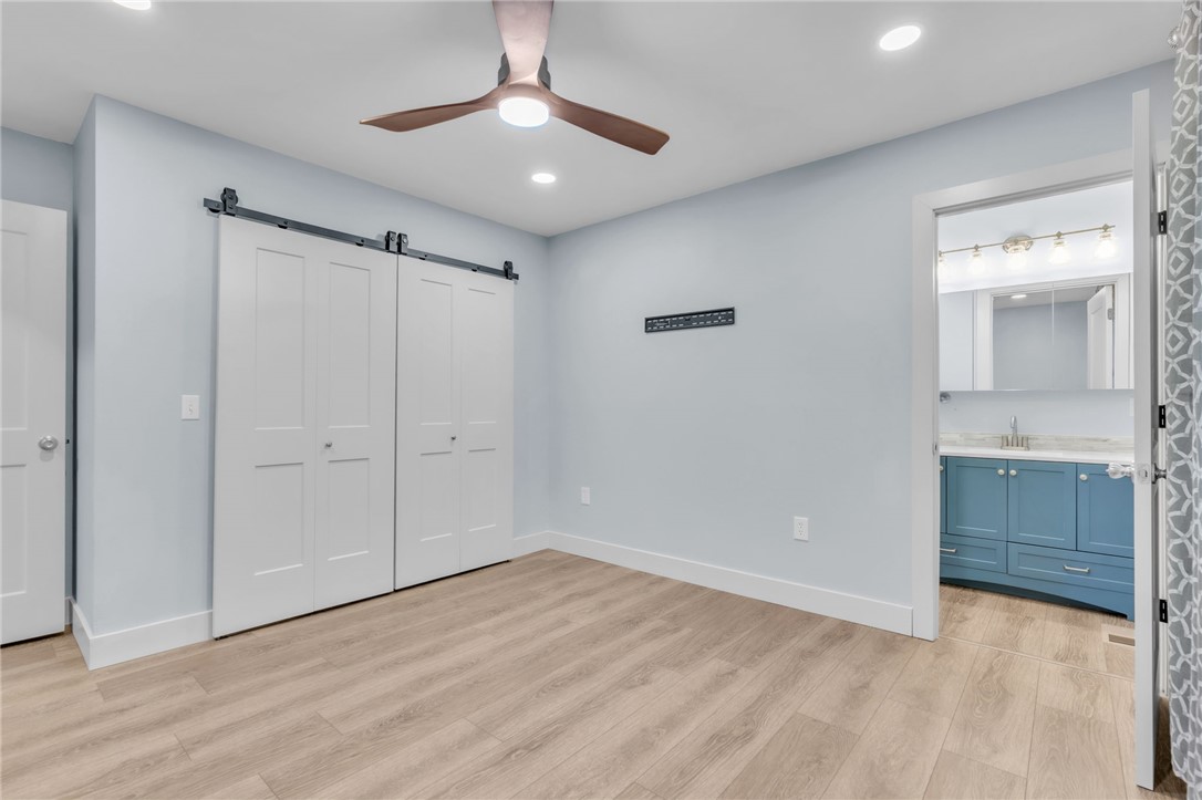 2038 Avant Circle Anderson, SC 29625 - Photo 21 of 32 This airy bedroom features modern barn doors, sleek flooring, and convenient access to a private bathroom.