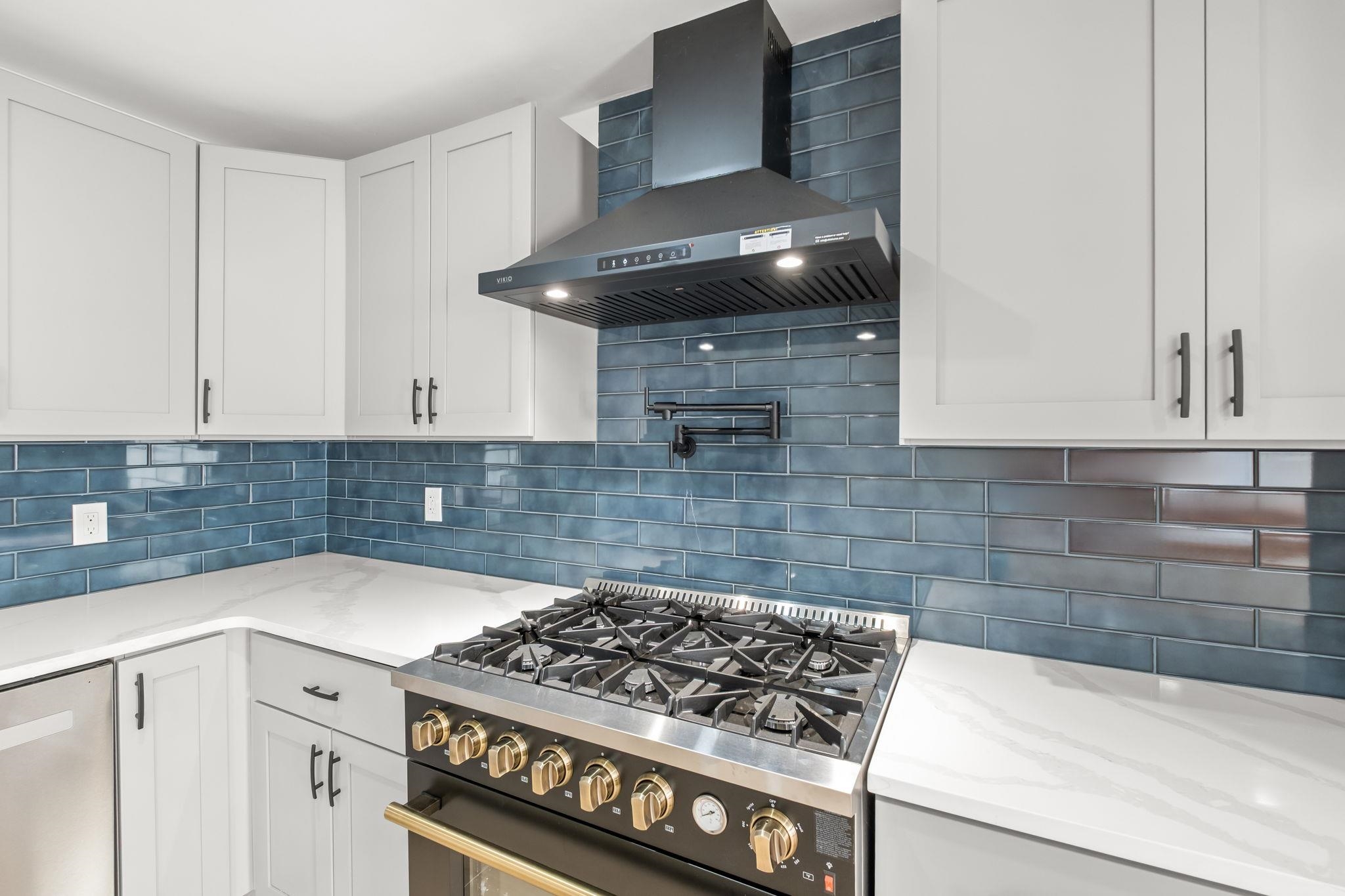 6224 Benjestown Road Memphis, TN 38127 - Photo 12 of 38 Kitchen featuring range with gas stovetop, white cabinetry, light stone countertops, tasteful backsplash, and stainless steel dishwasher