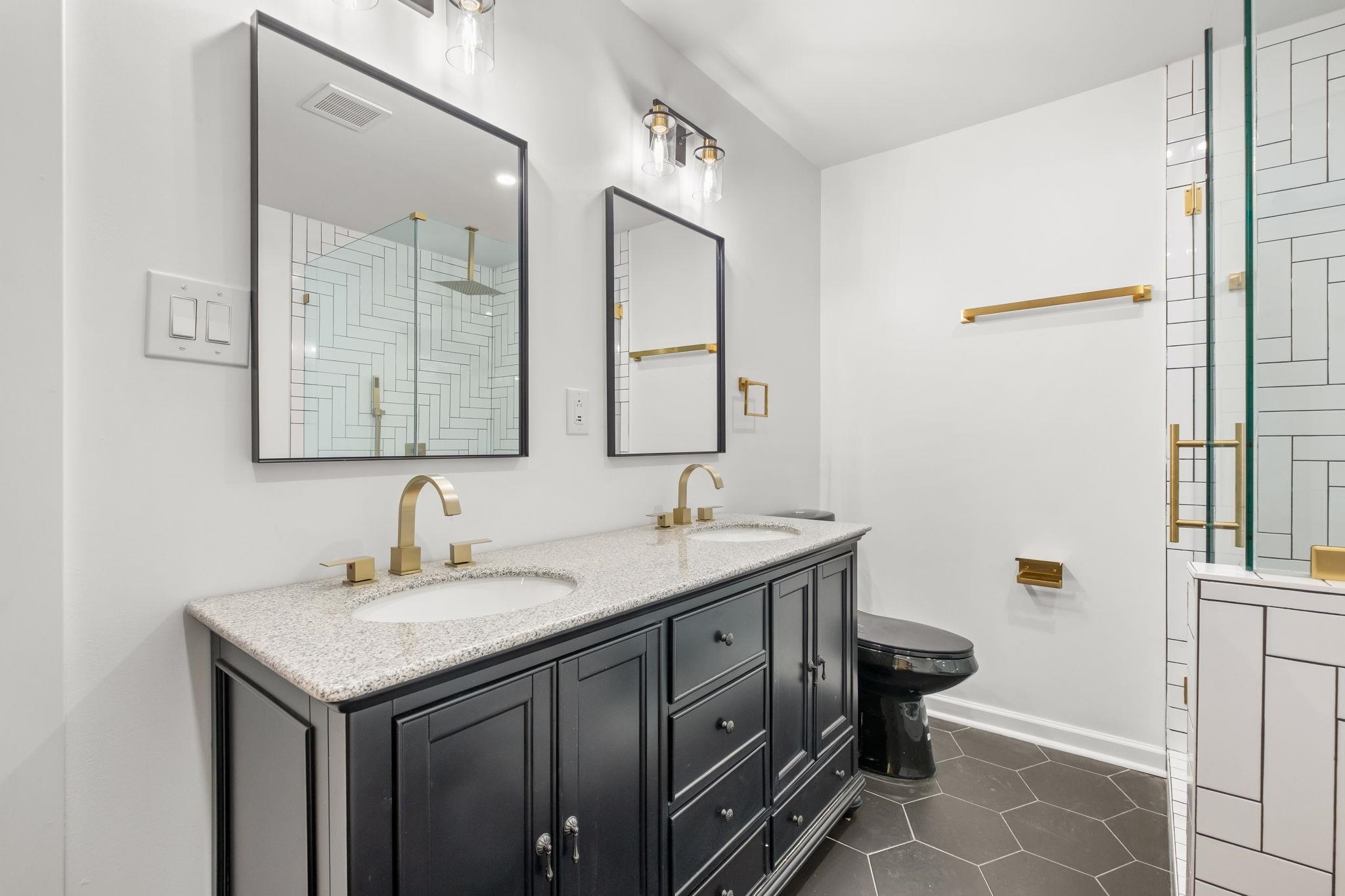 6224 Benjestown Road Memphis, TN 38127 - Photo 20 of 38 Full bath with double vanity, dark tile patterned floors, and a shower