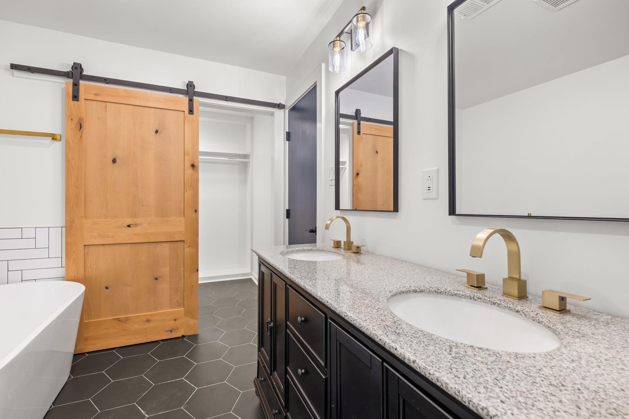 6224 Benjestown Road Memphis, TN 38127 - Photo 21 of 38 Bathroom featuring double vanity, dark tile patterned flooring, and a freestanding tub