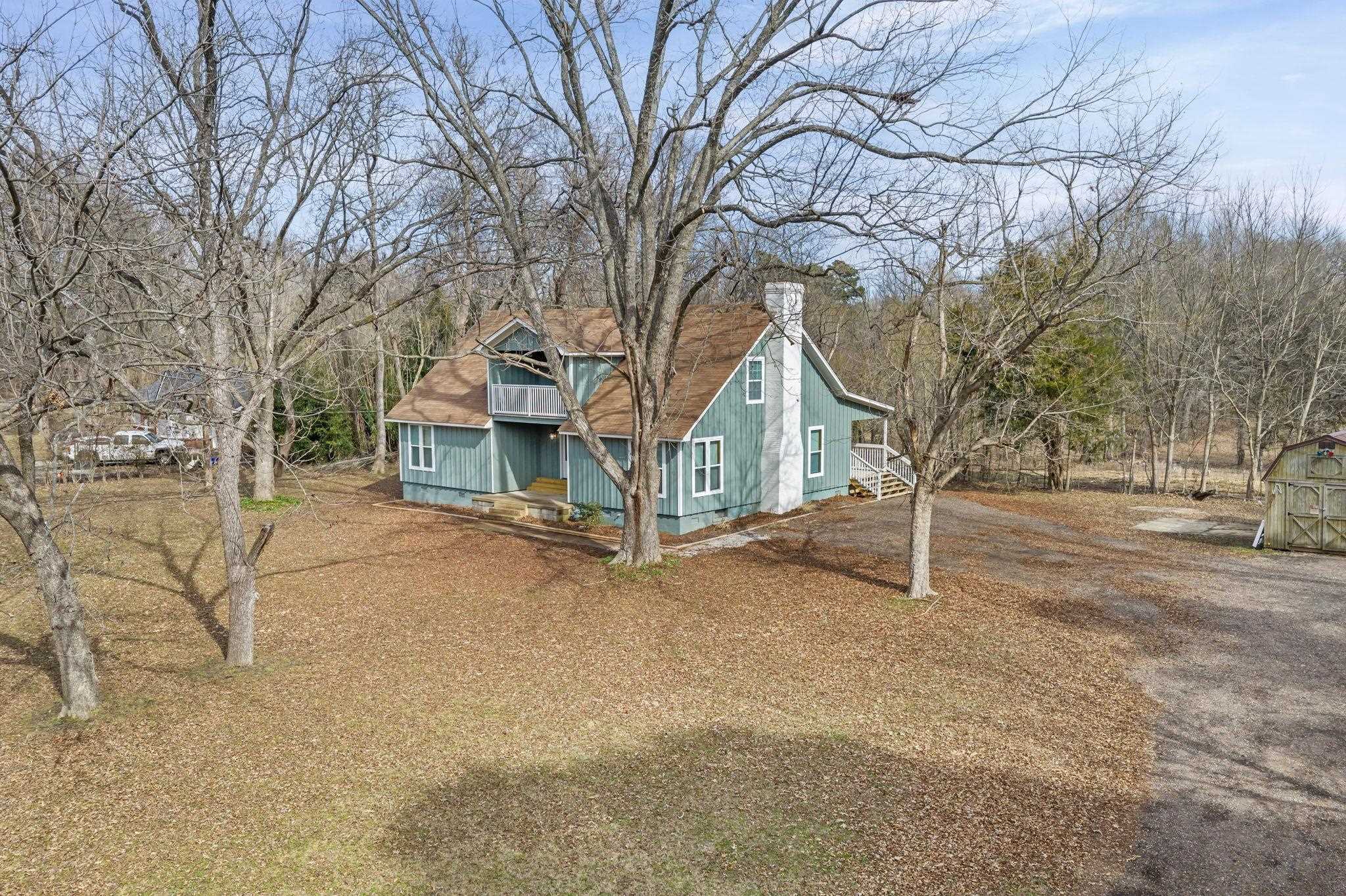 6224 Benjestown Road Memphis, TN 38127 - Photo 37 of 38 View of home's exterior featuring a chimney, an outbuilding, a shingled roof, and view of scattered trees