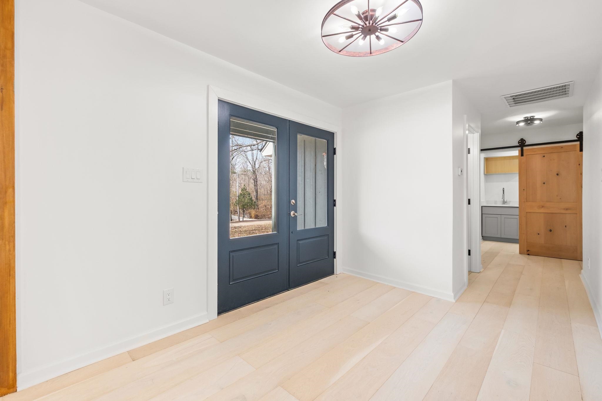 6224 Benjestown Road Memphis, TN 38127 - Photo 5 of 38 Foyer with a barn door, light wood-style flooring, and suspended lighting