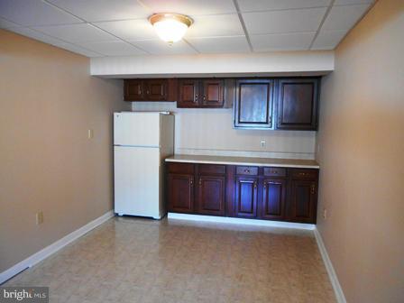 117 Michelle Drive Ranson, WV 25438 - Photo 20 of 24 a kitchen with a refrigerator and wooden cabinets